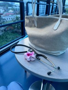 a stethoscope sitting on top of a table next to a bag and flower