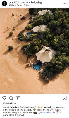 an aerial view of several tents in the desert with trees surrounding them and water running through it