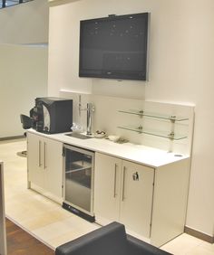 a television mounted on the wall above a kitchen counter