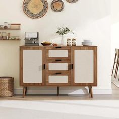 a white and brown cabinet in a room with plates on the wall next to it