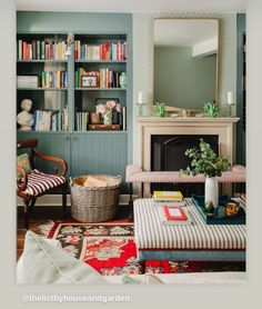 a living room filled with furniture and a fire place in front of a bookshelf