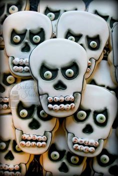 there are many decorated sugar cookies with eyes and teeth on them, all in the shape of skulls