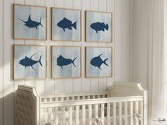 a baby's room with four framed pictures on the wall and a crib