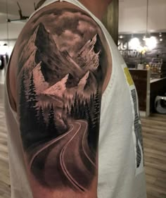 a man with a mountain and road tattoo on his arm