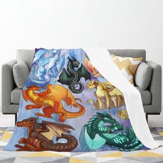 a couch with a blanket on it that has different types of dragon images all over it