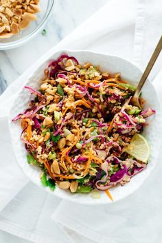 a white bowl filled with coleslaw, carrots and peanuts