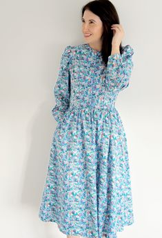 "🤍VINTAGE LIBERTY LONDON BLUE FLORAL MIDI COTTON DRESS🤍 A beautiful classic Spring Summer a line dress which can be dressed up or down. **WELCOME TO SEASONALLY DRESSED** BRAND ~ MARION DONALDSON (famously known for using Liberty fabrics) 👗 Fits like a size: UK  12 TODAY  Label Size: UK 14 Model is a UK 12 | 5ft 6 | Perfect fit  🌎 International Sizing: See converter within Frequency Asked Questions Underarm to underarm (Flat): 19.5\" Waist (Circumference): 30\" Hips (Circumference): free  Shoulder to Hem:49 \" Sleeve length (underarm to cuff):18\" ⭐️ ITEM DESCRIPTION ⭐️ A very rare Marion Donaldson dress using Liberty floral print fabric | The dress is a line shape and has lining | Buttons to the waist | Hidden back zip | Original label and hem | Blue piping details | Ideal for weddings Modest Blue Midi Dress For Garden Party, Long Sleeve Smock Dress For Garden Party, Blue Modest Dress For Garden Party, Modest Blue Dress For Garden Party, Vintage Floral Print Casual Dress, Blue Retro Dress For Garden Party, Vintage Floral Print Dress For Casual Wear, Retro Blue Dress For Garden Party, Blue Knee-length Vintage Dress For Vintage Fashion