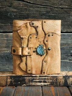 a brown leather journal with blue stone in the middle