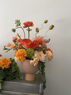 a vase filled with lots of flowers on top of a table