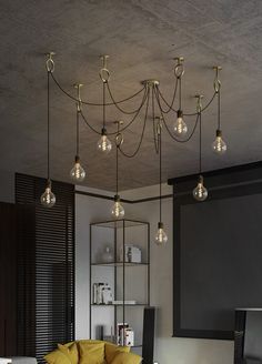 a living room filled with furniture and lots of lights hanging from the ceiling above it