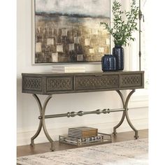 an ornate console table with two vases on it and a painting in the background