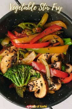 vegetables stir fry in a wok with black sesame seeds and red peppers on top