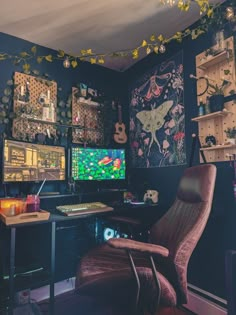 a computer desk and chair in a room with many pictures on the wall behind it