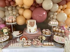 a table topped with lots of desserts and balloons