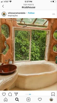 the bathroom is decorated in earth tones and features an oval tub, windows, and sink