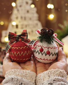 two knitted ornaments in the palm of someone's hands