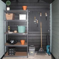 the inside of a storage shed with shelves and tools on it, including gardening implements