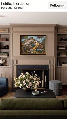 a living room filled with furniture and a painting on the wall above a fire place