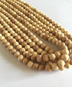 "Wood Beads 8 mm 545 beads (Unpolished Natural). These beads can be used to make your own Necklaces, Jewellery and Japa malas.  Since the wood beads are hand carved, they might not be perfectly uniform, and may have some imperfections related to wood. --> Price is for 5 strands (545 beads in total) --> Bead size 7-8 mm approximately --> The bead size is measured non- hole side Check other beads here - https://etsy.me/2xBmAsK Visit our shop here- https://etsy.me/2IgCTfg -------------------------- Wooden Beads For Jewelry Making, Wooden Round Beads For Jewelry Making, Round Wooden Beads For Jewelry Making, Natural Beaded Necklaces With Round Beads, Natural Round Beaded Necklaces, Buddhist Rosary, Sandalwood Mala, Beads Mala, Meditation Beads