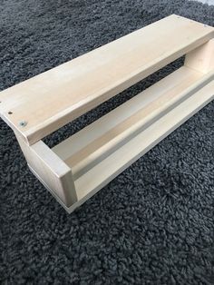 a wooden shelf sitting on top of a gray carpet