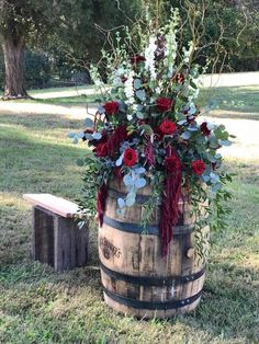 a wooden barrel filled with flowers and greenery