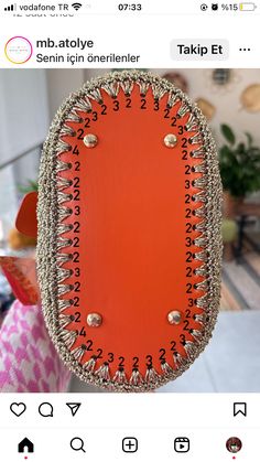 an orange purse with gold studs on the front and sides is being held up by someone's hand