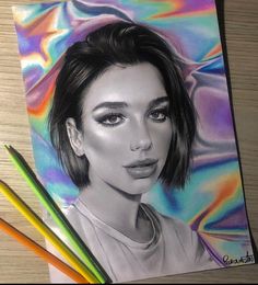 a pencil drawing of a woman's face on a piece of paper next to colored pencils