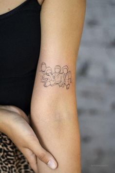 a woman with a tattoo on her arm that has three small dogs drawn on it