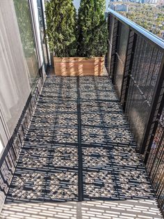 an outdoor bed on the side of a building with trees in the background and sun shining through