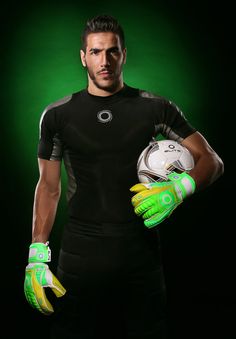 a man holding a soccer ball and gloves