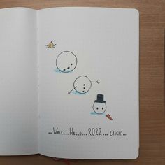 an open notebook with two snowmen on it