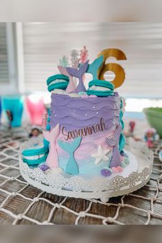 there is a birthday cake that has mermaid decorations on it, and the number eight