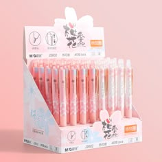 a display case filled with lots of pink and white pens on top of a pink background