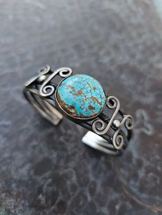 3 pulled and twisted silver ingot wires make the shank of this cuff, simply capped on the terminals. The natural turquoise is slightly domed, showing classic matrix of #8 turquoise, and has a velvety sheen. c 1920s-30s Interior Circumference: 6" not including gap of 1" Height: 1" Weight: 45g Condition: Because of the age and untreated quality of the stone, there are two small spots missing the turquoise from the host stone. Turquoise Patina Sterling Silver Cuff Bracelet, Adjustable Turquoise Cabochon Bracelet, Adjustable Sterling Silver Cuff Bracelet With Patina, Adjustable Sterling Silver Patina Cuff Bracelet, 30s Interior, Silver Ingot, Tree Jewelry, The Host, Jewelry Tree