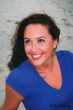 a woman in blue shirt smiling at the camera