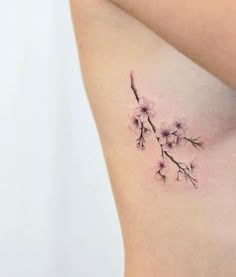 a woman's stomach with a small tattoo of flowers on the back of her body