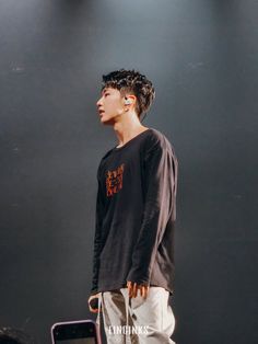 a young man standing on top of a stage holding a skateboard in his hand