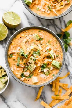 two bowls of quesadilla soup with tortilla chips on the side