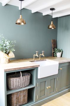 a kitchen with green painted walls and gold faucets on the sink countertop