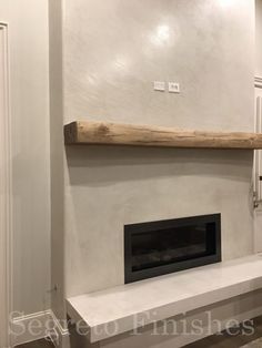 a white fireplace with a wooden mantle in the middle