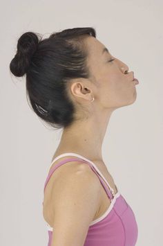 a woman with her eyes closed wearing a pink tank top and silver earrings