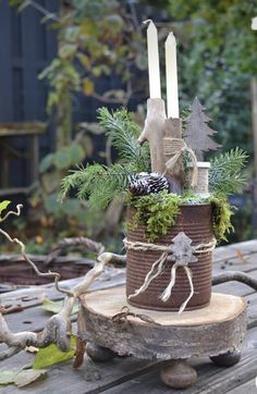 a wooden table topped with a potted plant and two candles