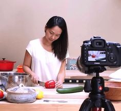 a woman standing in front of a camera preparing food