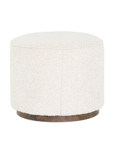 a white ottoman with wooden legs and a round cushion on the top, in front of a