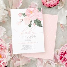 pink peonies are scattered around the baby's birth announcement