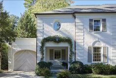 a large white house with ivy growing on the front door and side entrance to it