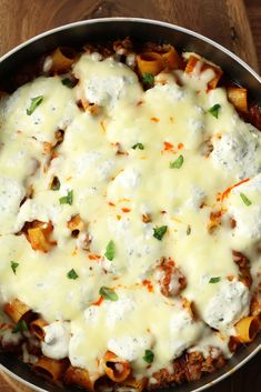 a casserole dish with cheese and meat in it on a wooden table top