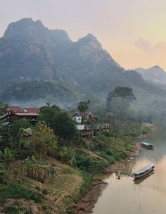 a river with boats on it and mountains in the background