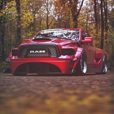 a red sports car parked in front of some trees