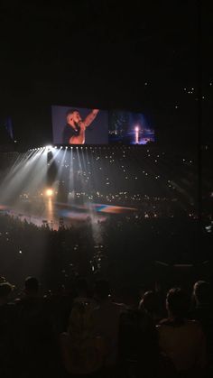 the stage is lit up with bright lights and people are watching something on it at night